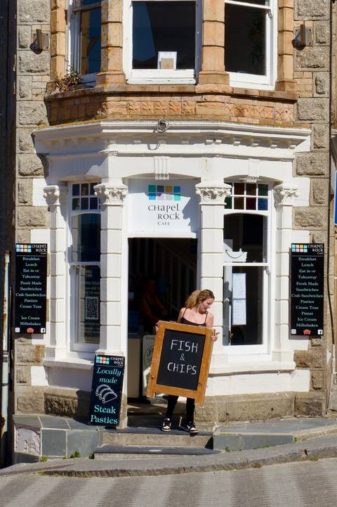 Person holding a sign outside Chapel Rock Cafe.