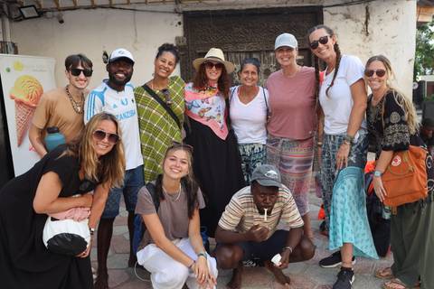 Group of people posing in a town with an ice cream sign.