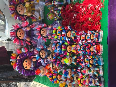 Colorful handcrafted dolls displayed on a table.