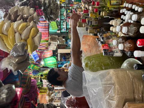 Market scene with a focus on a vendor and various goods.