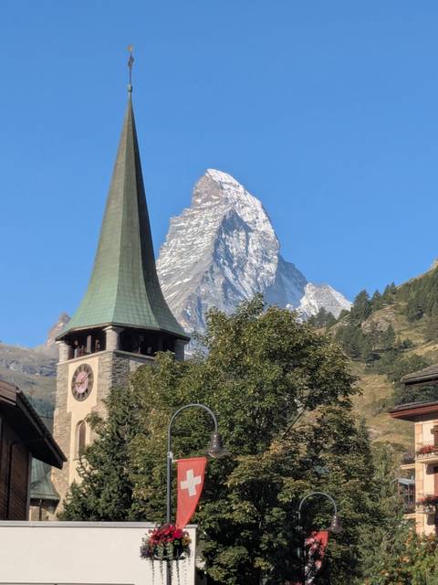       Church steeple in a village with the Matterhorn in the background.
  