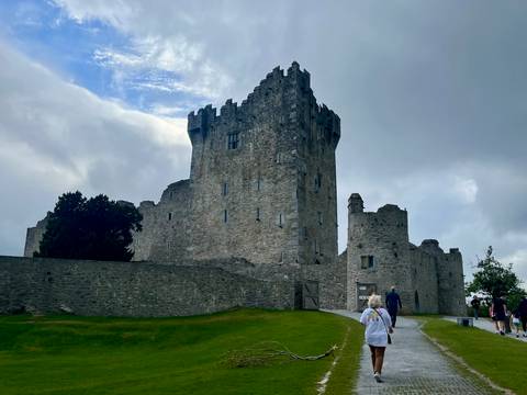 Stone castle building with cloudy sky.