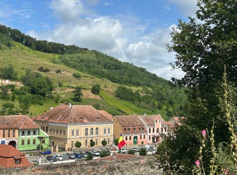       Colorful village with hills in the background.
  