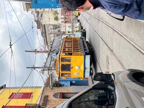       Vintage yellow tram on a city street.
  