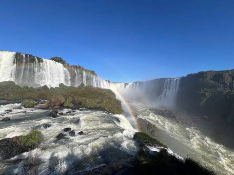       Waterfall with rainbow over the river.
  