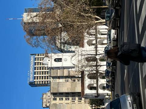       White building with clock tower and person walking.
  