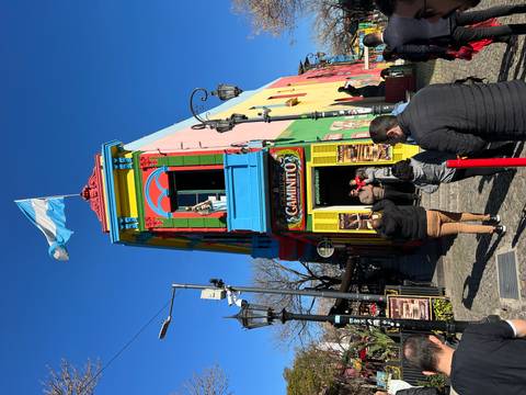       Colorful building with people and an Argentine flag.
  
