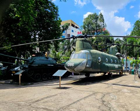Military helicopters and tanks on display in an outdoor museum.