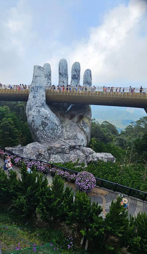       Close view of the Golden Bridge with hand sculptures.
  