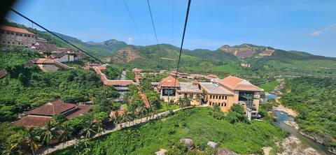 Aerial view of a resort town with lush green surroundings and mountains.