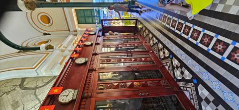 Interior of a historic building with decorative woodwork and clocks.