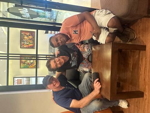 Three people sitting on a sofa indoors.