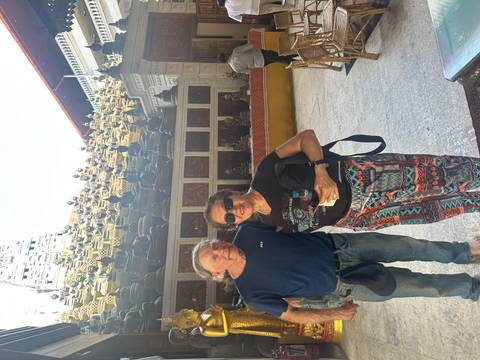 Couple posing at a temple with intricate carvings.