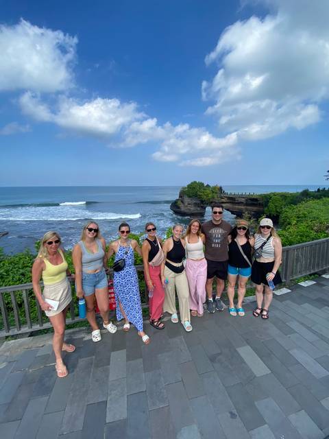 Group posing by a coastal viewpoint on a clear day.