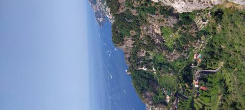 Scenic view of the Amalfi Coast with green terraces and a coastline.