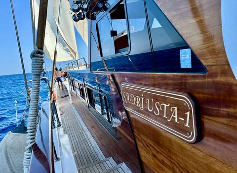 Side view of a boat on the sea with people on deck.