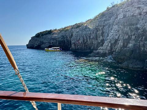 Rocky coastline with a tourist boat exploring.