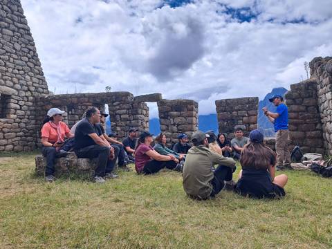 A guide explaining to a group sitting among ancient ruins.