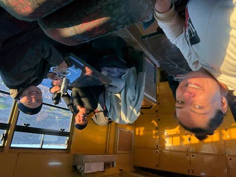 Group of people inside a safari vehicle eating.