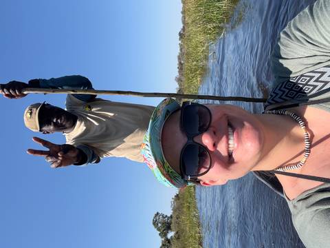 Two people in a canoe on water, one taking a selfie.