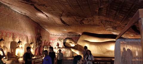       Interior of a temple with a reclining Buddha statue.
  