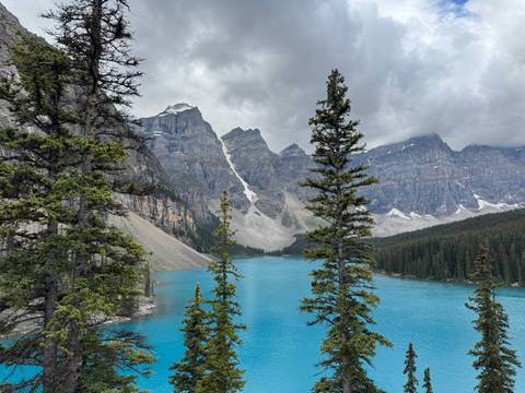Majestic lake with turquoise water and towering rocky mountains.
