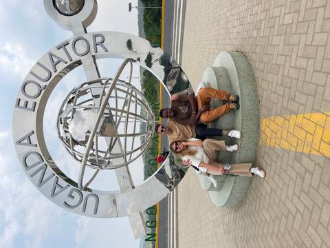 Three people posing in front of the Uganda Equator monument.