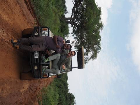       Two people posing next to a safari vehicle.
  