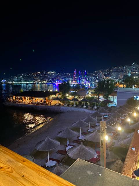 Night view of a vibrant seaside city with illuminated buildings.