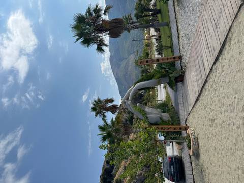 Decorative arch leading to a beach with palm trees.