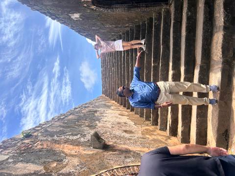 A man and a woman on stone stairs in a historic setting.