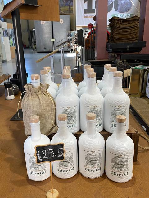 Bottles of olive oil neatly arranged for sale.