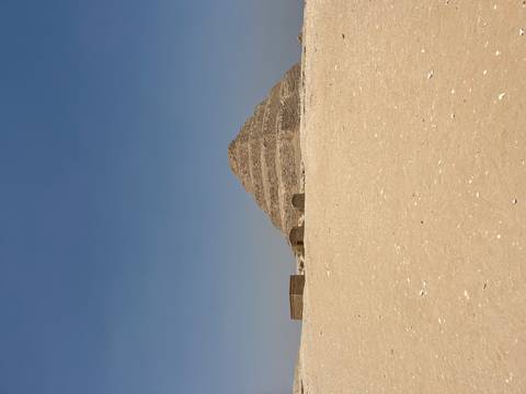 The Step Pyramid in a desert landscape with a clear blue sky.