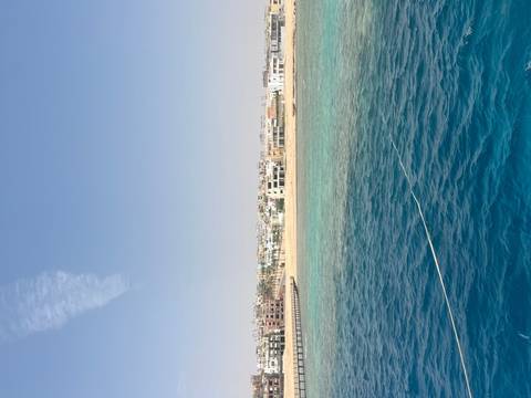       Coastal view with buildings by turquoise sea.
  