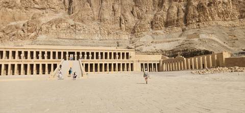 Mortuary Temple of Hatshepsut with tourists walking towards it.