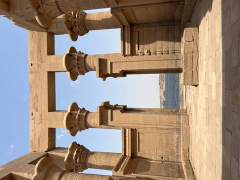 Stone pillars framing river view with clear sky.