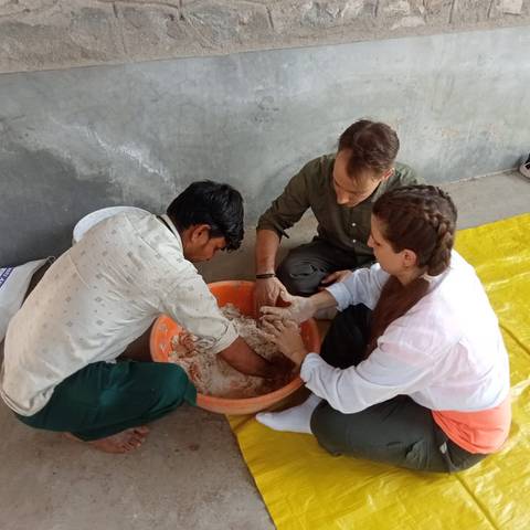 People kneading dough together.