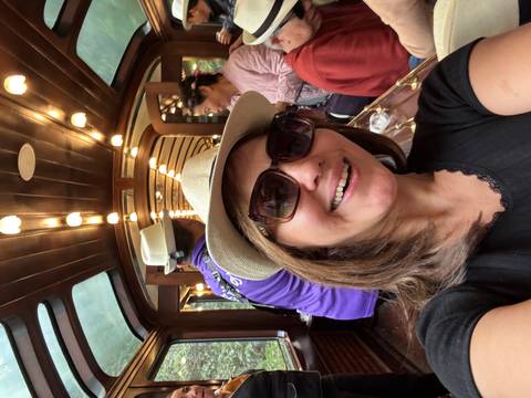       A woman smiling on a luxurious train carriage.
  