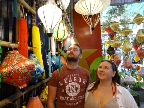       Two people looking at colorful lanterns in a shop.
  