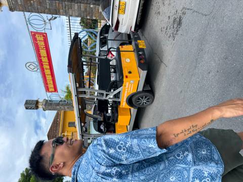       Person walking beside a sightseeing vehicle with a tourism sign.
  