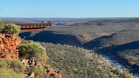 Panoramic view from a cliff with a viewing platform overlooking a valley.