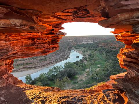 Rock formation framing a river view at sunset.