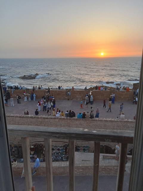 Crowds gathered on the seaside promenade at sunset.