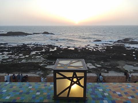 A coastal sunset view with colorful tile foreground.