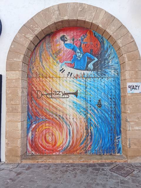       Decorated doorway with colorful artwork.
  