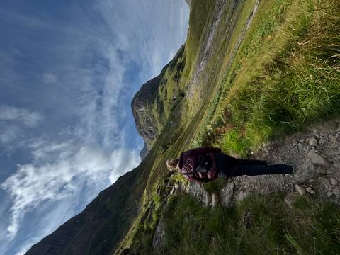 Person hiking up a rocky mountain path.