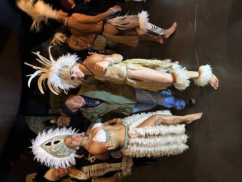 Person with traditional dancers in cultural attire.