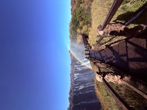       Rainbow over a walkway leading to the waterfall.
  
