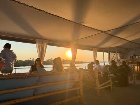       People relaxing on a boat during sunset.
  