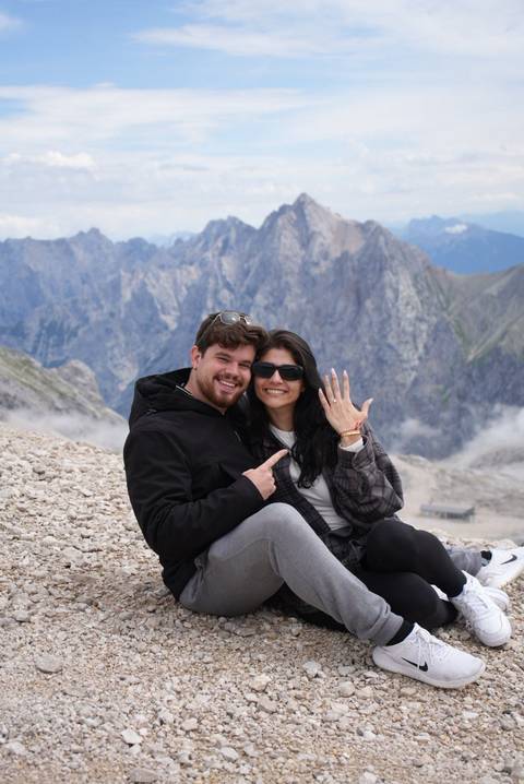 Couple posing with scenic mountains behind.